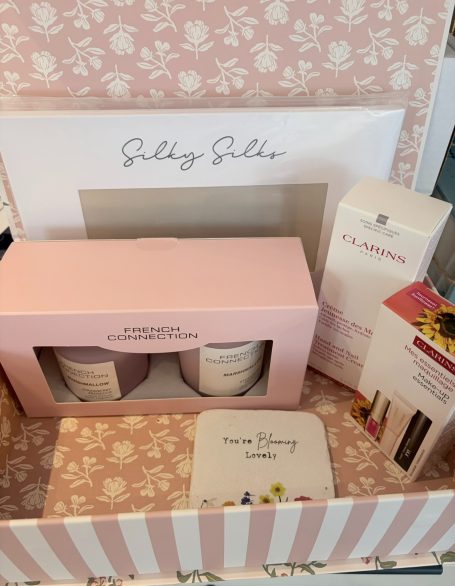 Luxury gift box from a customer in Australia to a relative in Leeds. The remit was luxury, loves Clarins cosmetics & candles. A gift box containing skincare products and candles, wrapped in floral packaging.